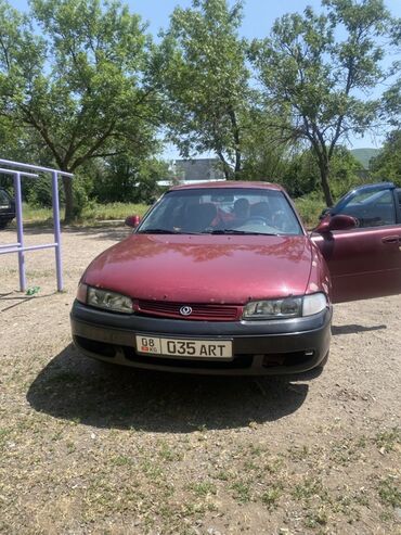 домкрат для машины: Автомобиль Mazda 626 красного цвета с кузовом седан. Оснащен передними