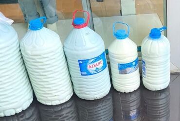 пластик терезе: Plastik qablarda təqdim olunan təbii süd. Hər bir qabın üzərində