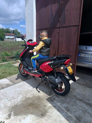 puska volana corsa c: Crveno-crni skuter marke Craus, sa crnim sedištem i crnim zadnjim