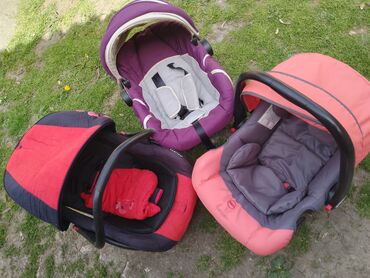 brojevi odeće za bebe: Tri dečija auto sedišta različitih boja. Svako sedište ima ručku za
