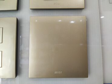 smart açar: MODI istehsalı olan qızılı rəngli divar açarı. Bu açar evinizdə və ya