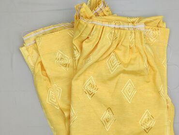 Żółte, używane spodnie unisex z wzorem w romby. Spodnie posiadają