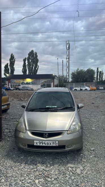 маленькая машина: Honda Fit – это компактный хэтчбек золотистого цвета, представленный в