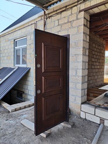 seyf qapilari: Tünd qəhvəyi rəngdə metal giriş qapısı, panelli dizaynı ilə seçilir