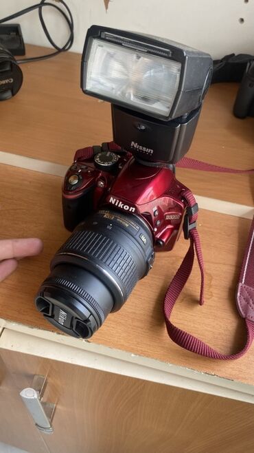 nar şiresi çeken: Nikon D3200 rəqəmsal SLR fotoaparatı, qırmızı rəngdə. Komplektə NIKKOR