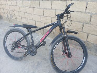 BMX brendinin qara rəngli dağ velosipedi. Qırmızı təkər diskləri və