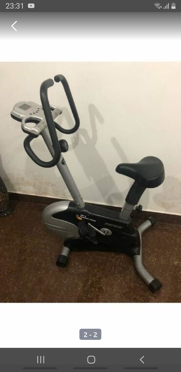 Elliptik trenajorlar: Qara və gümüşü rəngdə olan stasionar velosiped trenajoru. Üzərindəki