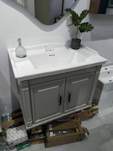 Taxta-şalban: Ağ rəngli keramika lavabo və boz rəngli ikiqapılı şkafdan ibarət hamam