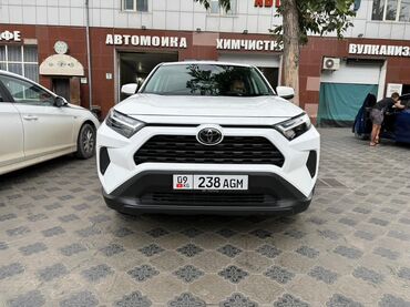 машина диска: Белый внедорожник Toyota RAV4 с заметным дорожным просветом