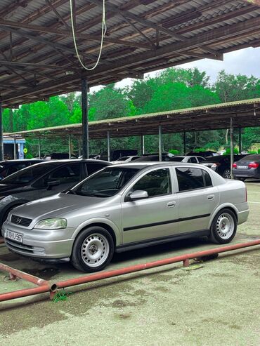 Gümüşü rəngli Opel Astra sedan, dörd qapılı dizaynı və geniş salonu