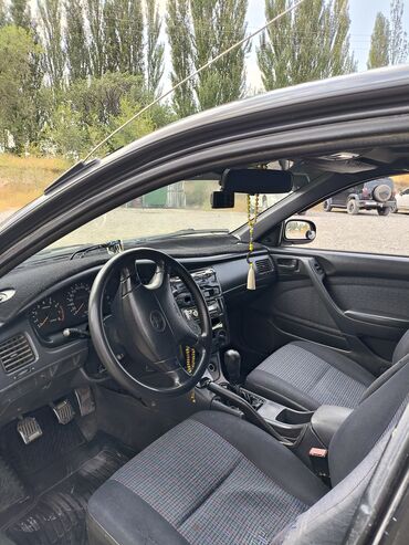 машина электирик: Седан Toyota Carina E, представленный в темно-зеленом цвете, оснащен