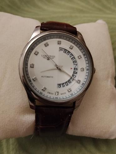 longiness: Longines üslubunda kişi qol saatı. Saat ağ rəngli siferblata malikdir — 1