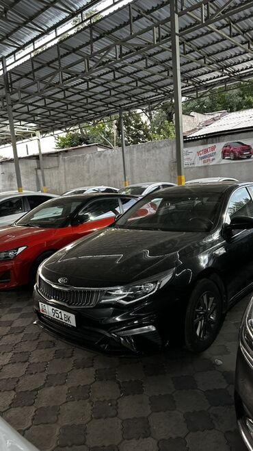 самая деловая машина: Черный седан Kia Optima с динамичным дизайном. Автомобиль оснащен