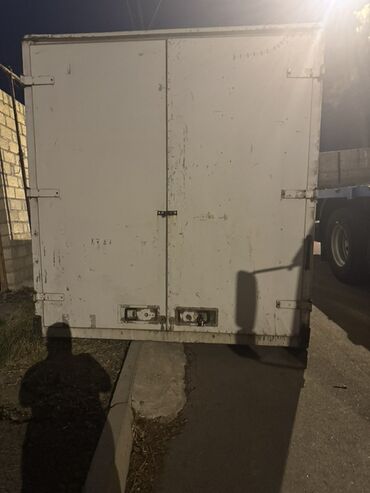 Konteynerlər: Bu böyük ağ rəngli yük konteyneri sənaye daşımaları üçün nəzərdə