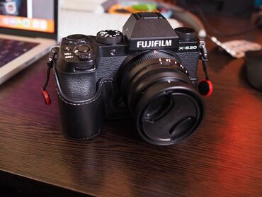 Qara rəngli, dəri kaburali Fujifilm X-S20 fotoaparatı. Yüksək