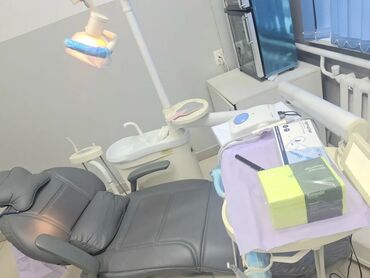 стоматологическое кресло: Стоматологическое кресло с серой обивкой и синим основанием. Кресло