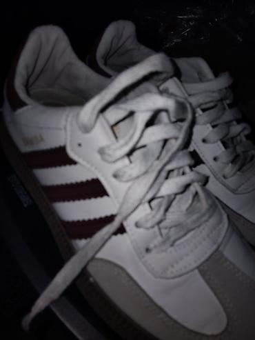 Adidas üslubunda klassik idman ayaqqabısı. Ağ rəngli korpus, yan