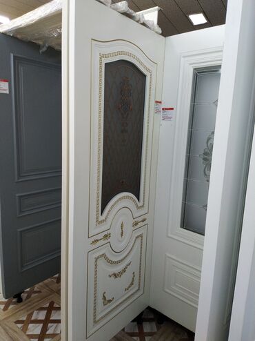 pol ucun taxta: Ağ rəngdə, üzərində qızılı ornamentləri olan qapı. Qapının mərkəzi