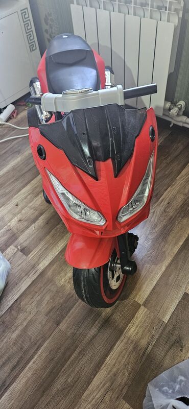 Uşaq üçün elektrik maşınları: Uşaqlar üçün nəzərdə tutulmuş qırmızı rəngli elektrik motosiklet. İki
