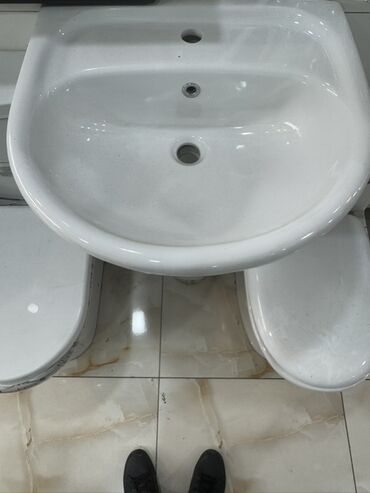 qizdirici krant: Ağ rəngdə, yarımdairəvi formalı, keramik lavabo. Bu lavabo divara