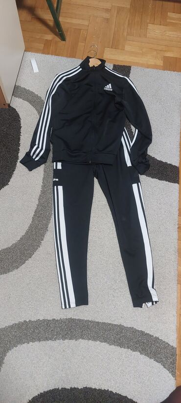 srbija duksevi sa kapuljacom: Crna Adidas trenerka sa belim prugama. Komplet se sastoji od gornjeg