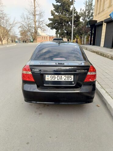 Chevrolet Aveo modeli tünd rəngdədir. Avtomobilin arxa hissəsində