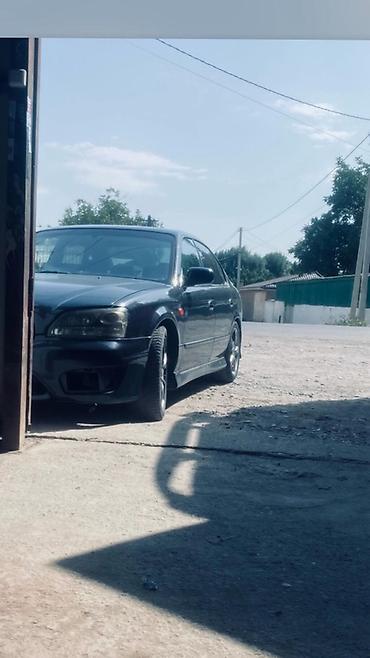Продаётся автомобиль (седан) тёмного цвета с легкосплавными дисками и