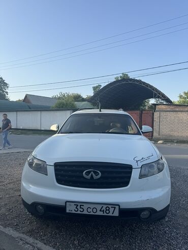 машина инфинити: Белый кроссовер Infiniti FX, оснащенный черными литыми дисками. Этот