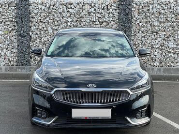 100000 сомдук машиналар: Черный седан Kia K7 (Cadenza) с панорамным люком на крыше. Автомобиль