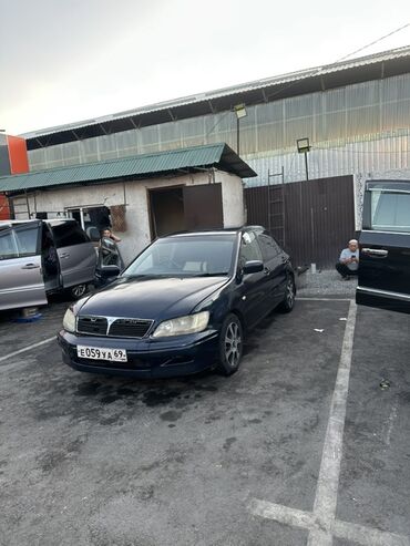 диск на машину: Седан Mitsubishi Lancer темно-синего цвета, оснащенный номерным знаком