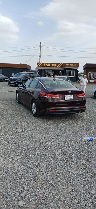 домик на колесо: Элегантный седан Kia Optima глубокого бордового цвета с классическим