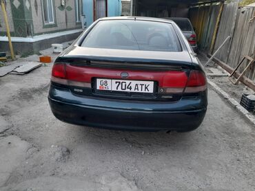 воздушный домкрат для авто: Зеленый седан Mazda 626, оборудованный механической коробкой передач