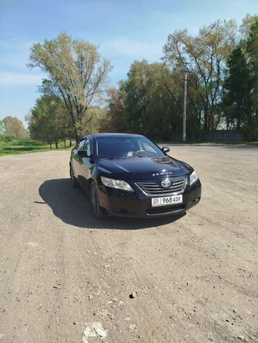 автомобили в рассрочку без первоначального взноса: Черный седан Toyota Camry с тонированными стеклами и легкосплавными