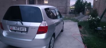 машина дишовый: Серебристый хэтчбек Honda Fit с компактным дизайном, четырьмя дверями