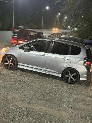 меняю участок на авто: Серебристый хэтчбек Honda Fit с пятидверным кузовом, спортивными