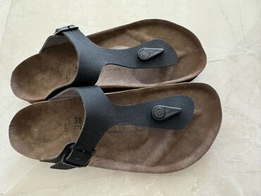 шлепанцы через палец: Пара сандалий Birkenstock Gizeh черного цвета. Они имеют ремешок между