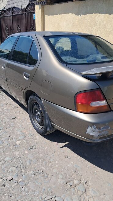 дом на колосах: Седан Nissan Altima в цвете "бронза" с четырьмядверями, оснащенный