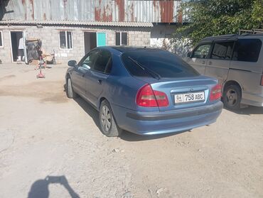 маленькая машина: Синий седан Mitsubishi Carisma с плавными линиями кузова и обтекаемым