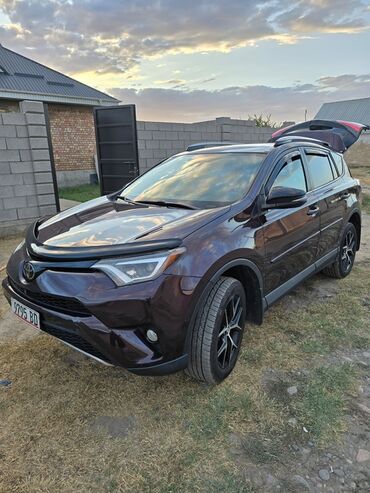 семиместные машины: Кроссовер Toyota RAV4 темного цвета с багажником, открытым сзади