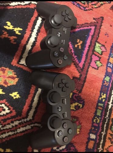 plesdesn: PlayStation 2 oyun konsolu və 3 ədet qara rəngli . Konsol