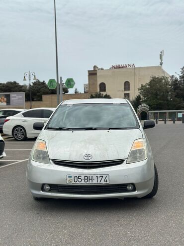 prius disk təkər: Gümüşü rəngdə "Toyota Prius" avtomobili, hibrid mühərriki ilə ekoloji