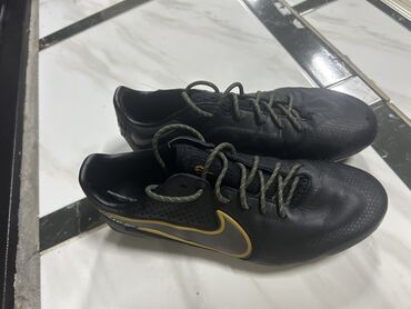 зальники для футбола: Черные футбольные бутсы Nike с золотистым логотипом-галочкой. Обувь на