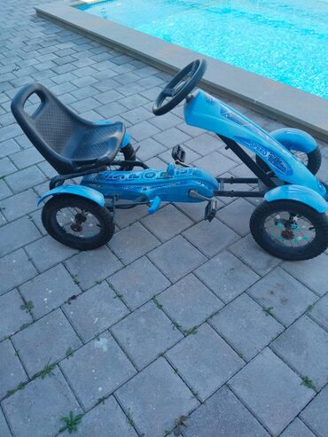 Mavi rəngdə uşaq pedal go-kartı. Uşaqların əyləncəsi üçün nəzərdə