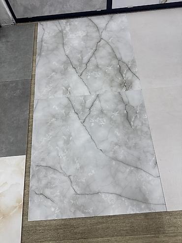 Керамогранитные плиты, формат крупный (ориентировочно 60×60 см). На