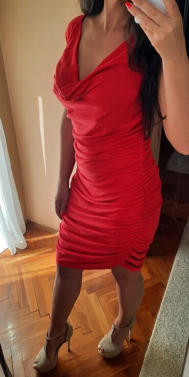 ponco sa krznom: Crvena uska nabrana haljina sa dekolteom valovitim. Dosta je