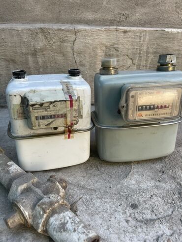 счётчик воды: Два газовых счетчика. Один счетчик белого цвета, с видимыми следами