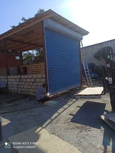 Giriş qapıları: Mavi rəngdə, rulon tipli qaraj qapısı. Metal materialdan