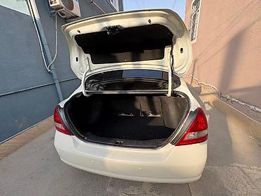 nisan note: Ağ rəngli Nissan Tiida sedan. Avtomobilin salonu açıq bej tonlarda — 4