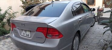 Honda: Honda Civic Hybrid sedan – gümüş rəng, 4 qapı, arxa spoylerli. Hibrid — 4