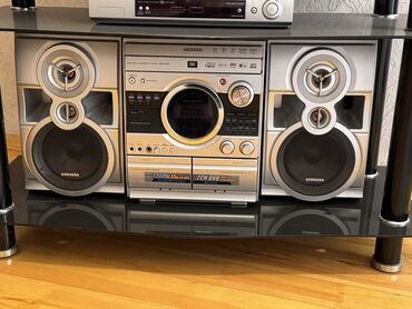 Микрофоны: Samsung brendinin qara rəngli şüşə rəfdə yerləşən gümüşü rəngli musiqi